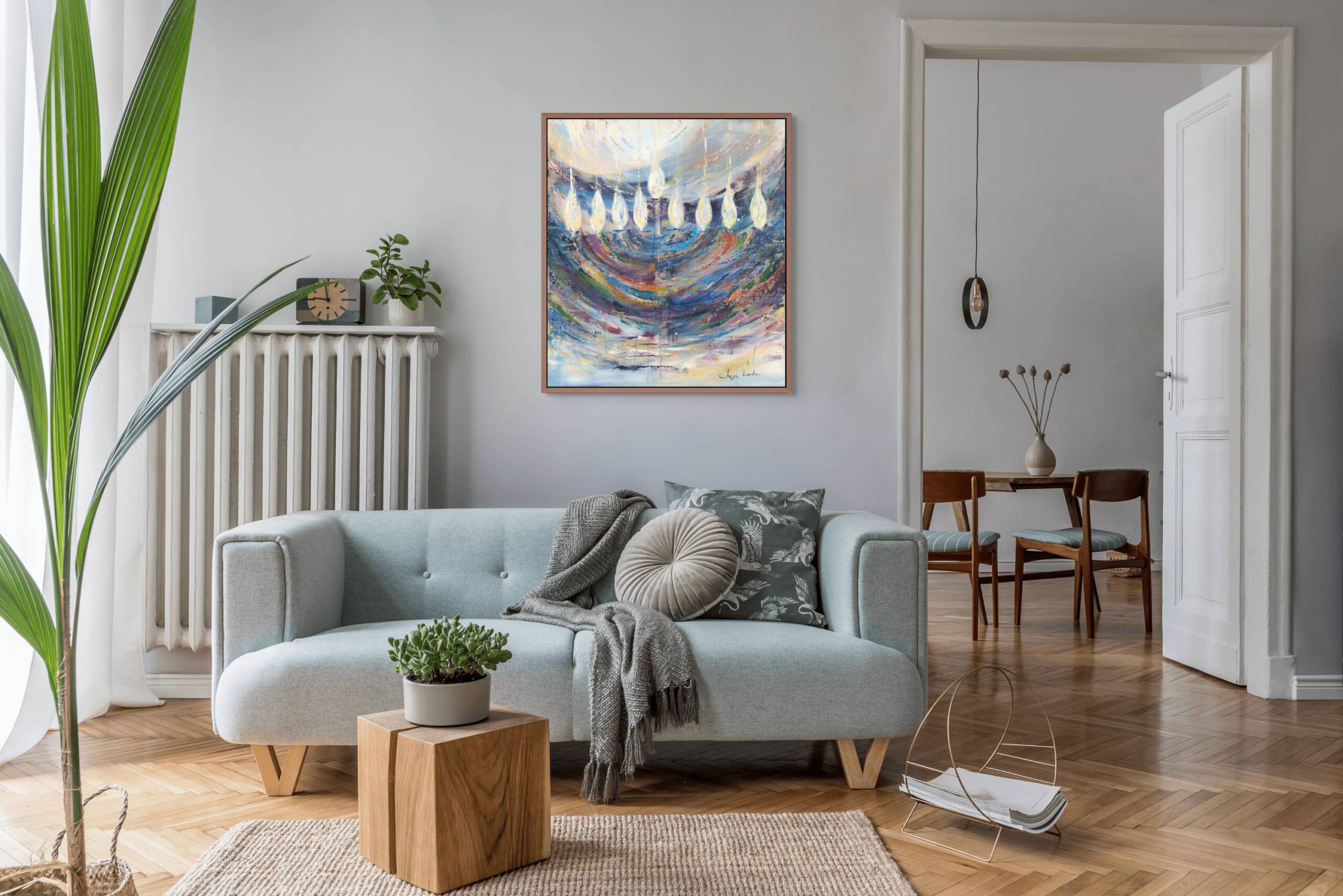 Painting of a vibrant menorah with dynamic brushstrokes hanging above a modern 3-seater sofa next to a radiator and open door in a contemporary living room.