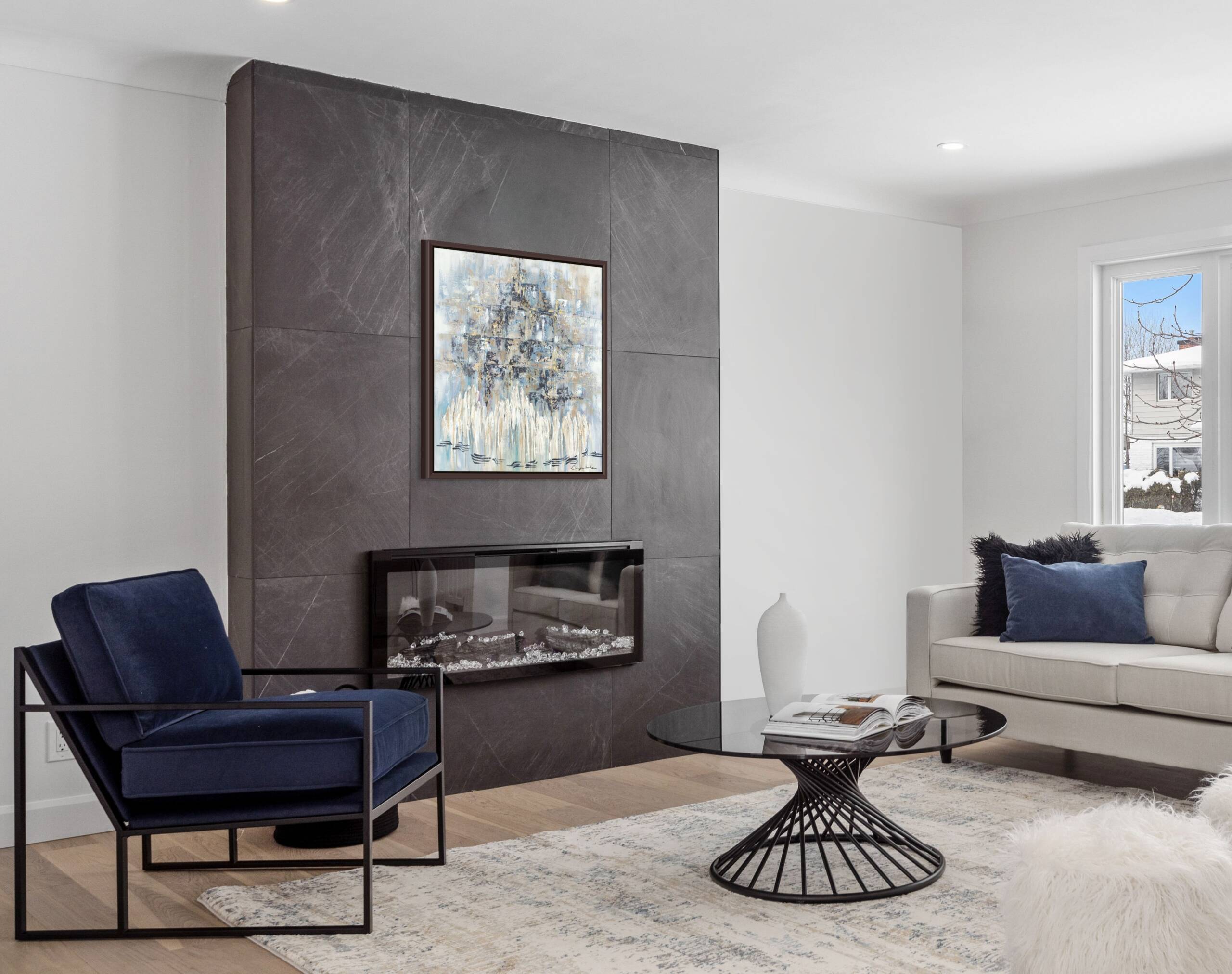 Mockup of "Wrapped in Faith, Bathed in Gold" painting hung above a sleek glass fireplace in a contemporary living room.